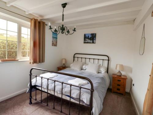 a bedroom with a bed and a window at Fferm Porthdafarch South Farm House in Holyhead
