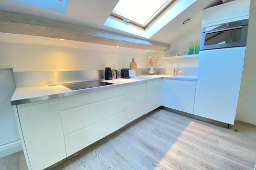 d'une cuisine avec des placards blancs et une lucarne. dans l'établissement Modern & bright 4-room apartment in Cannes Banane, à Cannes