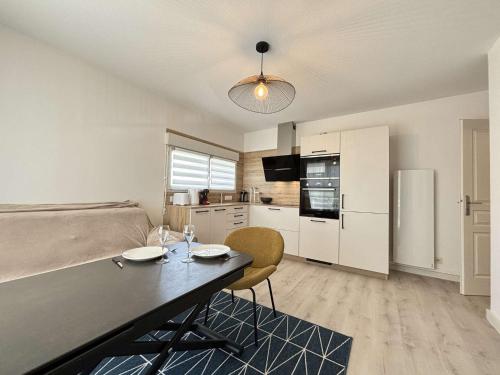 un salon avec une table et une cuisine dans l'établissement Appt 2 pièces LA ROCHELLE - LR150-217, à La Rochelle