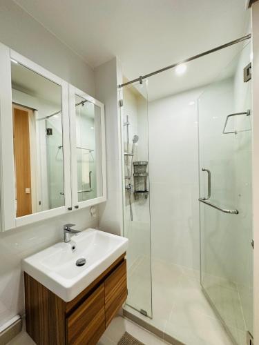 a bathroom with a sink and a glass shower at 6th Avenue Sukhumvit BKK 407 BTS Asoke Nana in Bangkok