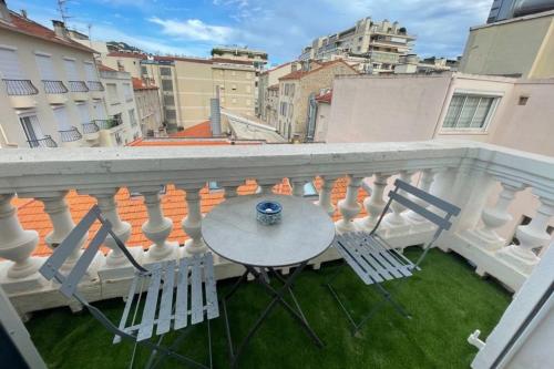 un balcon avec une table et des chaises sur un balcon dans l'établissement Luxurious 4 bedrooms 1min beaches & 3min Palais, à Cannes