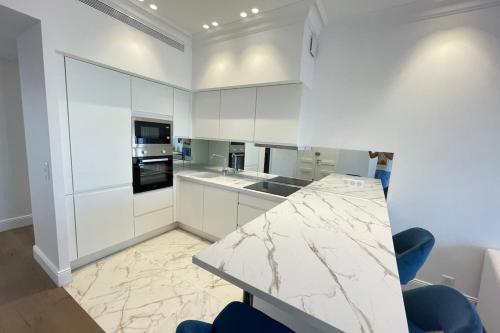 une cuisine avec des armoires blanches et un comptoir en marbre dans l'établissement Luxurious 4 bedrooms 1min beaches & 3min Palais, à Cannes