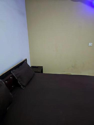 Una cama con una manta negra y una almohada. en Hotel Janhvi, en Rewa