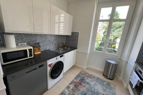 une cuisine avec un lave-linge et un micro-ondes dans l'établissement Nice 2 bedrooms Meynadier at 2 min BeachPalais, à Cannes