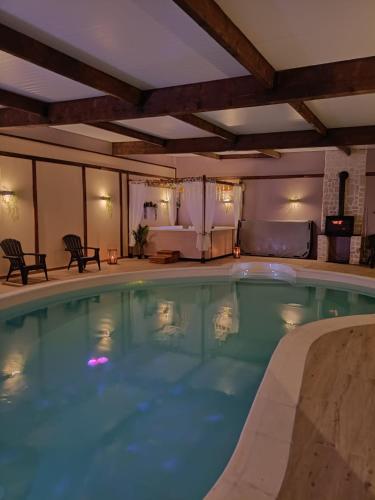 une grande piscine dans une chambre d'hôtel dans l'établissement La Grange Aux Hirondelles - Chambre romantique, à Woignarue
