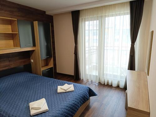 a bedroom with a blue bed with two white towels on it at Lime house in Kyustendil