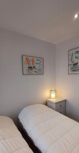 une chambre avec deux lits et une table avec une lampe dans l'établissement Charmante escale aux Sables d'Olonne, à Les Sables-dʼOlonne