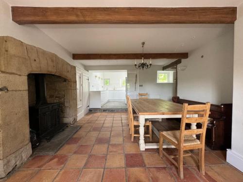 una sala da pranzo con tavolo e camino di Prior Hall Farm Cottage - 3 bedroom luxury cottage in center of Malham a Malham