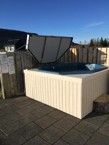 a large hot tub sitting on top of a patio at Álftröð Guesthouse in Brautarholt