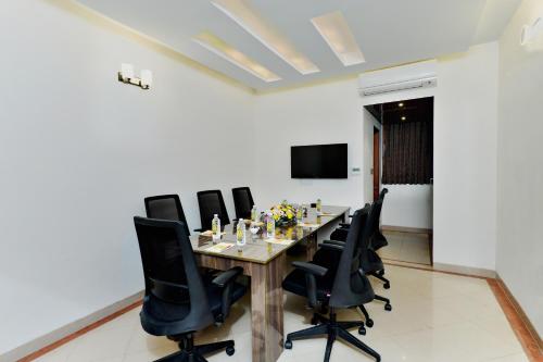 a conference room with a long table and black chairs at The Luxant Hotel in Bengaluru