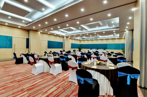 a large banquet hall with tables and chairs at The Luxant Hotel in Bengaluru