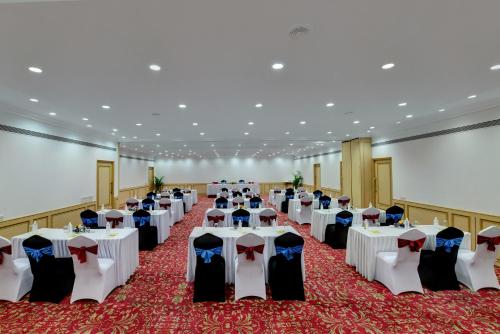 a banquet hall with white tables and chairs at The Luxant Hotel in Bengaluru