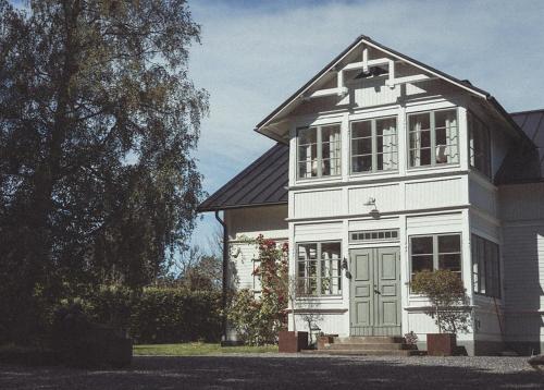 a white house with a green door on a street at Folk och Fä in Grisslehamn