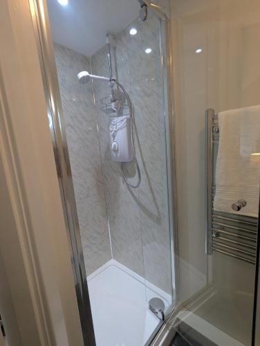 a shower with a glass door in a bathroom at Sleepy Hollow at Heatherbank in Dornie