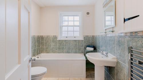 a bathroom with a tub and a toilet and a sink at Pilgrims Way in Elie
