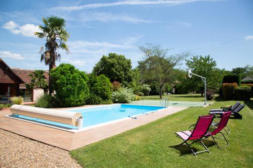 - une piscine dans une cour avec 2 chaises dans l'établissement Le Cocon des Châteaux de la Loire, à Fougères-sur-Bièvre