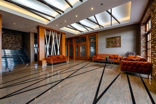 a lobby with orange leather couches and a staircase at Hotel Alhar in Lubliniec