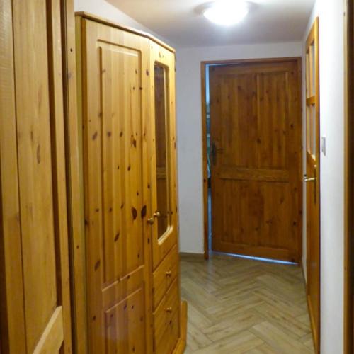 a room with wooden walls and a door and a hallway at Aktywna Agroturystyka in Stare Jabłonki