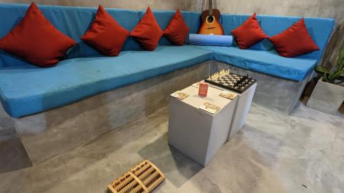 a blue couch with red pillows and a table at Soul Villas & Cabana Near Beach with Pool in Tangalle