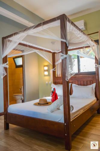 a bedroom with a canopy bed with a hat on it at Palmares Beach Hotel in Andjamen