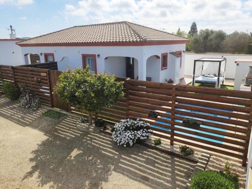 a house with a wooden fence in front of it at Casa Moisés Atardecer in El Palmar