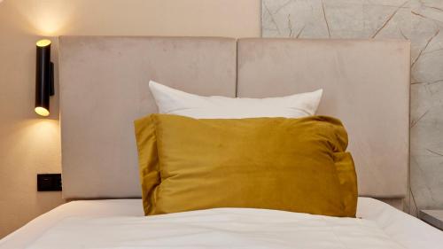 a yellow pillow sitting on top of a bed at Hoffmanns Weinstube in Bernkastel-Kues
