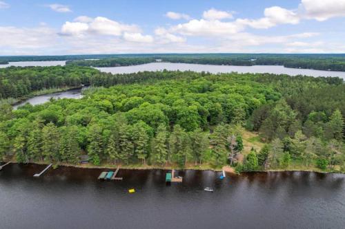 an island in the middle of a lake with trees at Lake Breeze Luxury Executive Retreat in Three Lakes