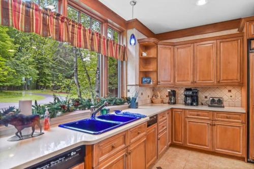 a kitchen with a sink and a large window at Lake Breeze Luxury Executive Retreat in Three Lakes