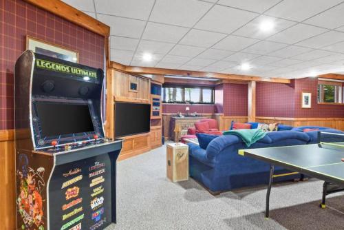 a gaming room with a large blue couch and a table at Lake Breeze Luxury Executive Retreat in Three Lakes