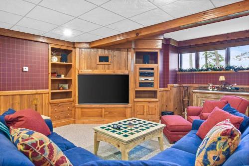 a living room with a blue couch and a television at Lake Breeze Luxury Executive Retreat in Three Lakes