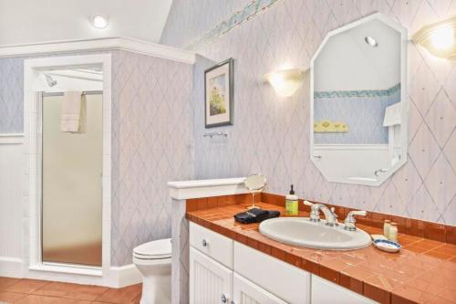 a bathroom with a sink and a toilet and a mirror at Lake Breeze Luxury Executive Retreat in Three Lakes