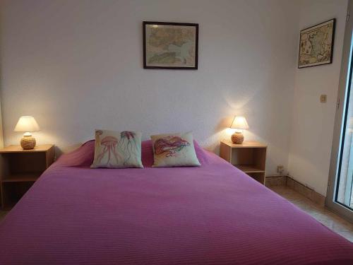 - une chambre avec un grand lit violet et deux lampes dans l'établissement 4DOM11 Appartement avec terrasse et parking, proche plage, à Collioure
