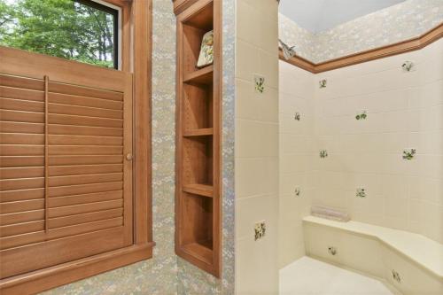 a bathroom with a shower with a wooden door at Lake Breeze Luxury Executive Retreat in Three Lakes