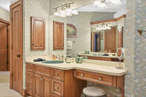 a bathroom with a sink and a large mirror at Lake Breeze Luxury Executive Retreat in Three Lakes
