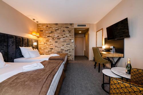 a hotel room with two beds and a table at Hotel Alhar in Lubliniec