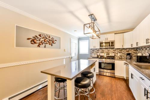 a kitchen with white cabinets and a table and stools at Matterhorns Hunter Lodge in Hunter