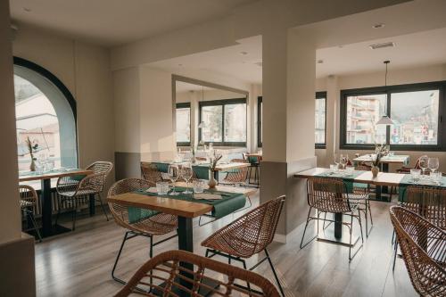 a restaurant with tables and chairs and windows at El Niu de Martinet in Martinet
