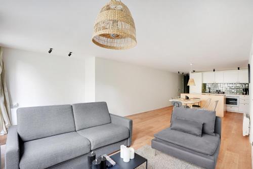 un salon avec un canapé et une chaise dans l'établissement Appartement équipé - Parking - Proche commerces, à Rosny-sous-Bois