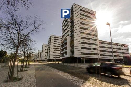 a car driving in front of a tall building at Oriente Rio Apartments by APT IIN - Parque das Nações in Lisbon