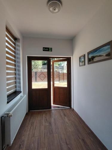 an empty room with a door and wooden floors at Casa MonyBeea in Silvaşu de Sus