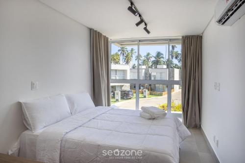 une chambre avec un lit et une grande fenêtre dans l'établissement NLU - Condomínio completo na Praia do Marceneiro, à Barra do Camaragibe