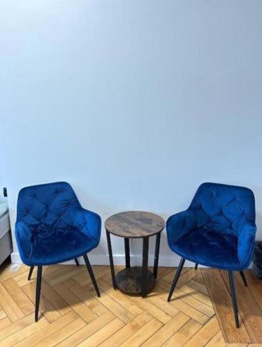 two chairs and a table in a room at Kopernik Premium Rooms Apartment in Toruń