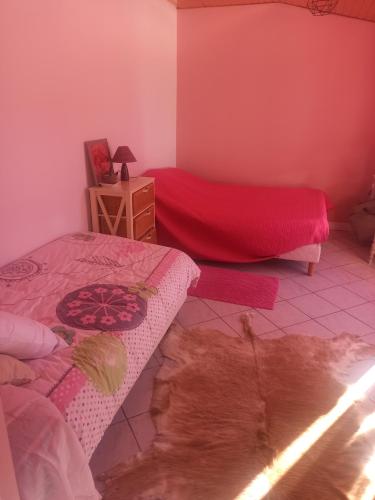 - une chambre avec un lit et une couverture rouge dans l'établissement La campagne, à Montgivray
