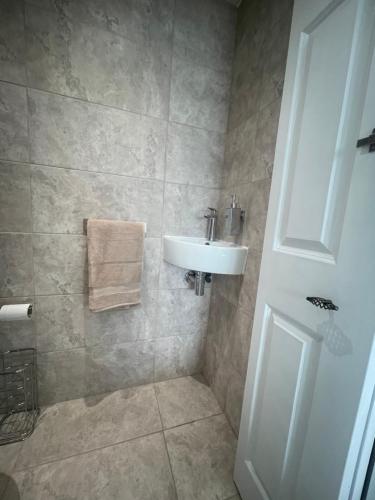 a bathroom with a sink and a shower at New luxurious and spacious guest suite in Banstead in Banstead