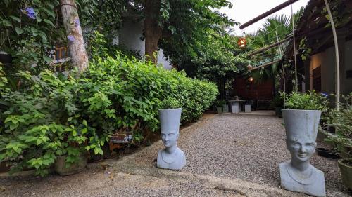 two concrete vases sitting in the middle of a garden at Soul Villas & Cabana Near Beach with Pool in Tangalle