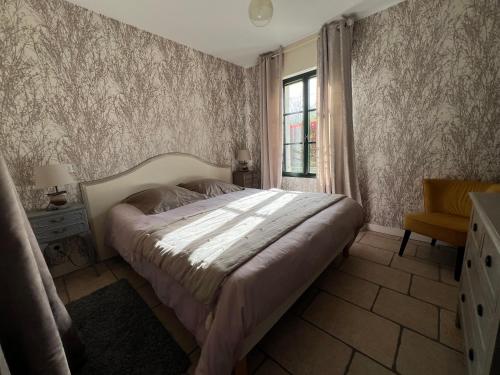 une chambre avec un grand lit et une fenêtre dans l'établissement Le Cocon des Châteaux de la Loire, à Fougères-sur-Bièvre