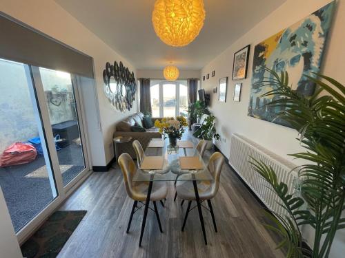a dining room with a table and chairs in a living room at 2 Bed Town Centre Apt in Porthcawl, parking, Wifi ,Sky & Netflix in Porthcawl