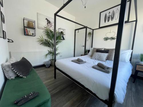 a bedroom with a black and white canopy bed at 2 Bed Town Centre Apt in Porthcawl, parking, Wifi ,Sky & Netflix in Porthcawl