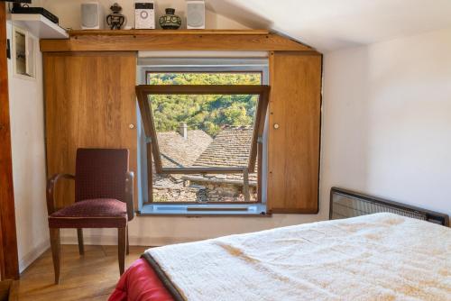 - une chambre avec une fenêtre, un lit et une chaise dans l'établissement Gîte Location 2/4 personnes à Palhères, à Villefort