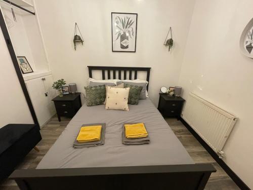 a bedroom with a bed with two yellow towels on it at 2 Bed Town Centre Apt in Porthcawl, parking, Wifi ,Sky & Netflix in Porthcawl
